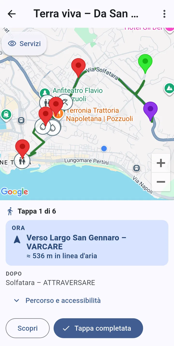 Schermata reale di un percorso attivo a Pozzuoli: mappa con il tracciato verde, le tappe numerate e la posizione dell’utente; sotto, «Tappa 1 di 6», ora verso Largo San Gennaro a circa 536 metri, dopo la Solfatara. Dimostra un contenuto usato da una persona sul posto.